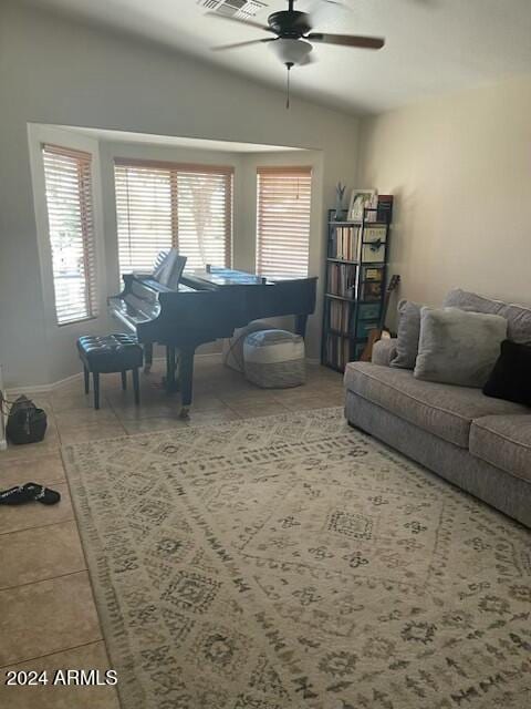 living room with ceiling fan, tile patterned flooring, and lofted ceiling