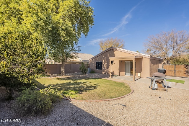 rear view of house with a yard and a patio