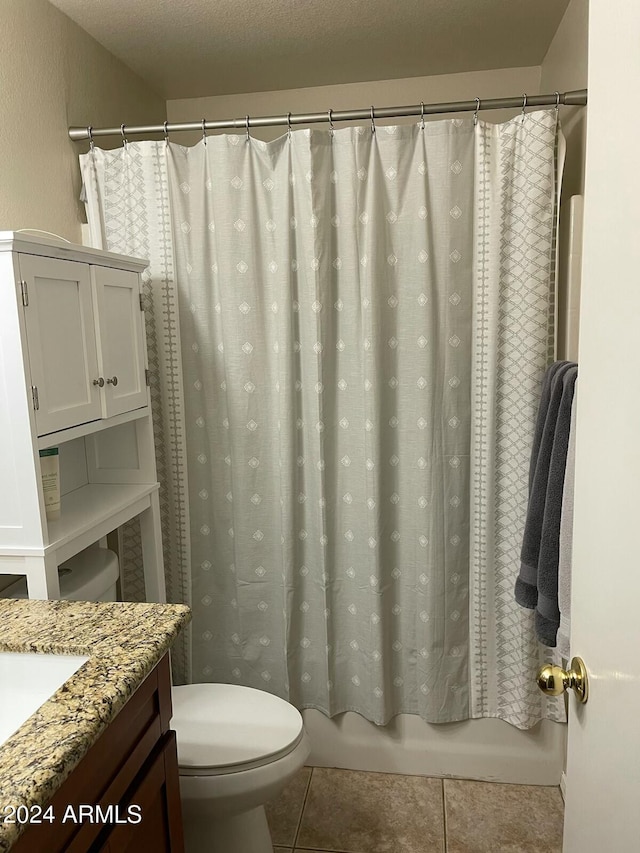 full bathroom with toilet, vanity, tile patterned flooring, a textured ceiling, and shower / bath combo with shower curtain