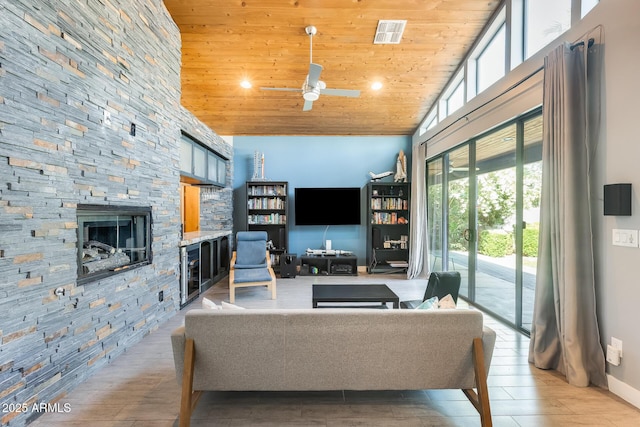 living room featuring a fireplace, high vaulted ceiling, recessed lighting, wooden ceiling, and visible vents
