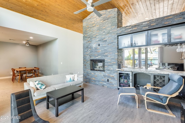 living area with wood finished floors, beverage cooler, high vaulted ceiling, wood ceiling, and a ceiling fan