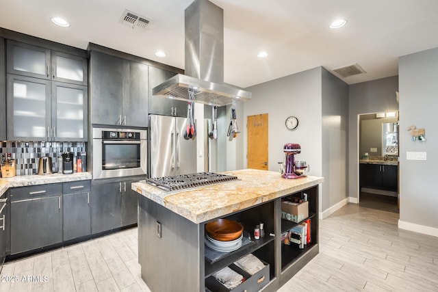 kitchen featuring light countertops, stainless steel appliances, island exhaust hood, and visible vents