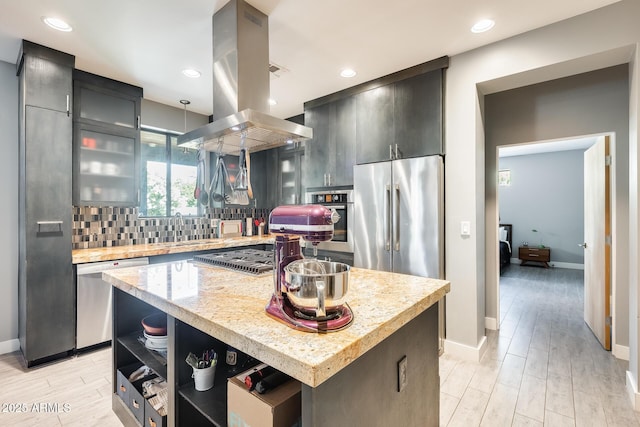 kitchen featuring open shelves, baseboards, island exhaust hood, a sink, and appliances with stainless steel finishes