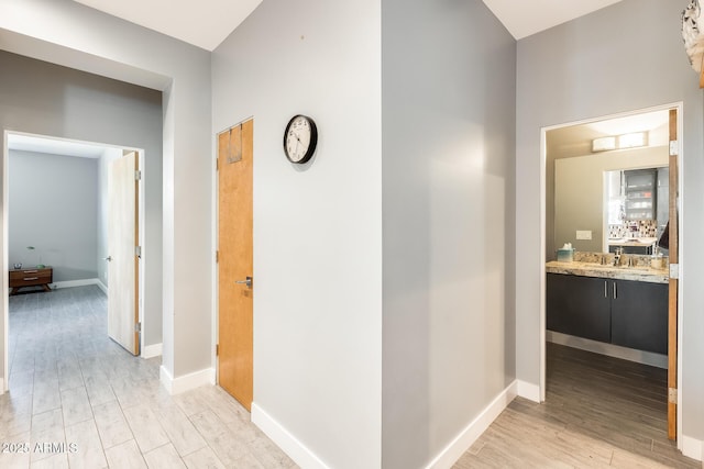 hall featuring baseboards and light wood-type flooring
