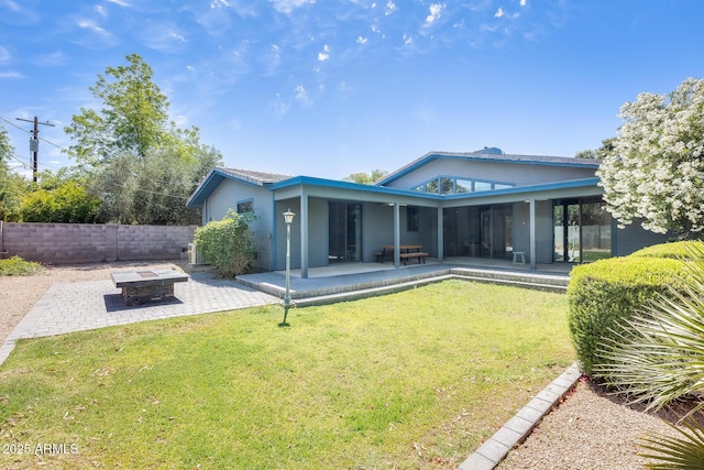 back of house with an outdoor fire pit, a patio area, a yard, and fence