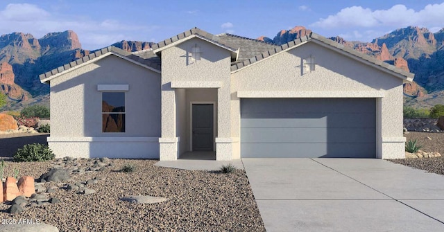 view of front of home with concrete driveway, an attached garage, and stucco siding