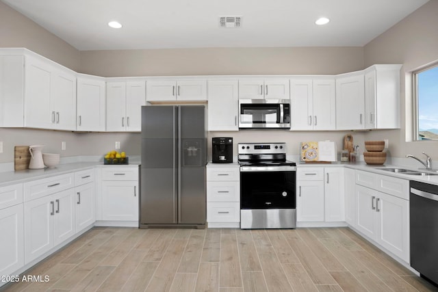 11203 E Crescent Ave, Mesa, AZ 85208 - kitchen featuring stainless steel appliances, a sink, white cabinetry, light countertops, and light wood-type flooring