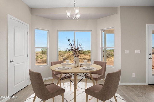 11203 E Crescent Ave, Mesa, AZ 85208 - dining area with light wood-style flooring, a notable chandelier, baseboards, and a healthy amount of sunlight