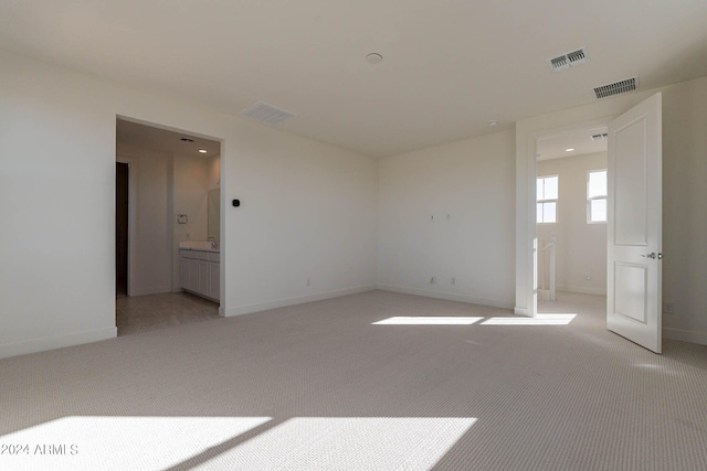 unfurnished room featuring light carpet