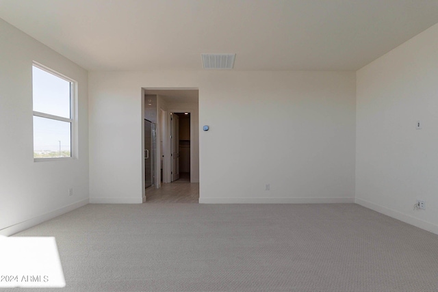 spare room featuring light colored carpet