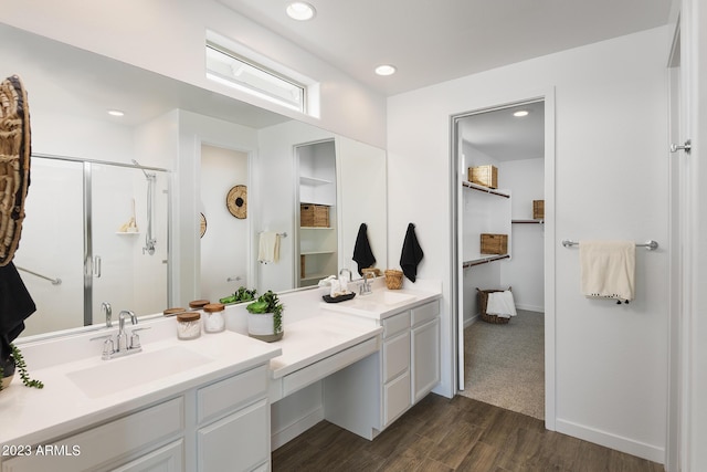 bathroom featuring hardwood / wood-style flooring, vanity, and a shower with shower door