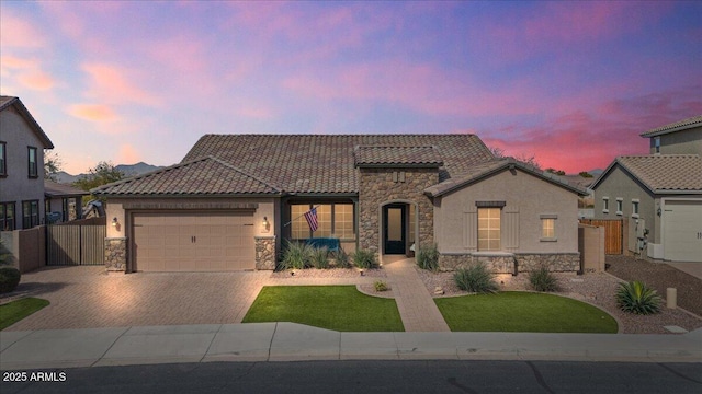 view of front facade with stone siding, an attached garage, and a tiled roof