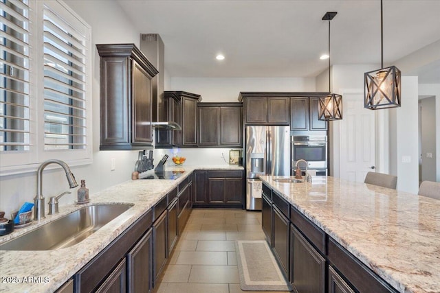 kitchen featuring a sink, stainless steel appliances, and light stone counters