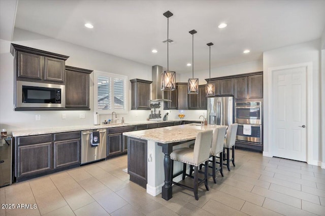 kitchen featuring dark brown cabinetry, appliances with stainless steel finishes, wall chimney exhaust hood, and a sink