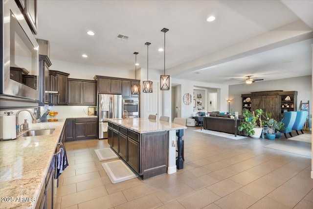 kitchen featuring a sink, stainless steel appliances, dark brown cabinetry, and visible vents