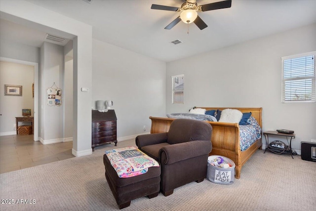 carpeted bedroom with visible vents, baseboards, and a ceiling fan