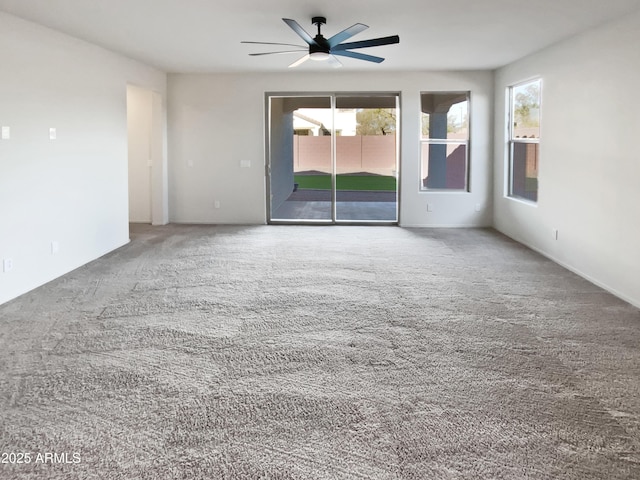 carpeted spare room featuring ceiling fan