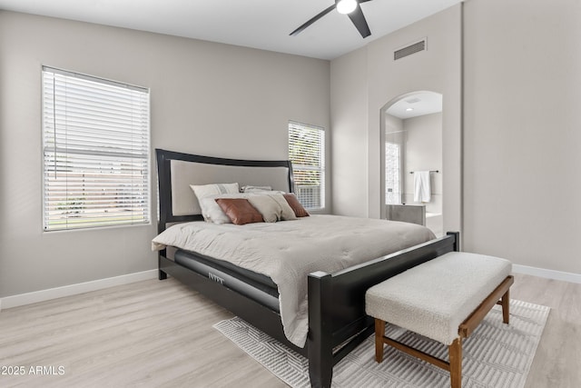 512 W Encinas St, Gilbert, AZ 85233 - bedroom featuring arched walkways, light wood-style flooring, baseboards, ceiling fan, and ensuite bath