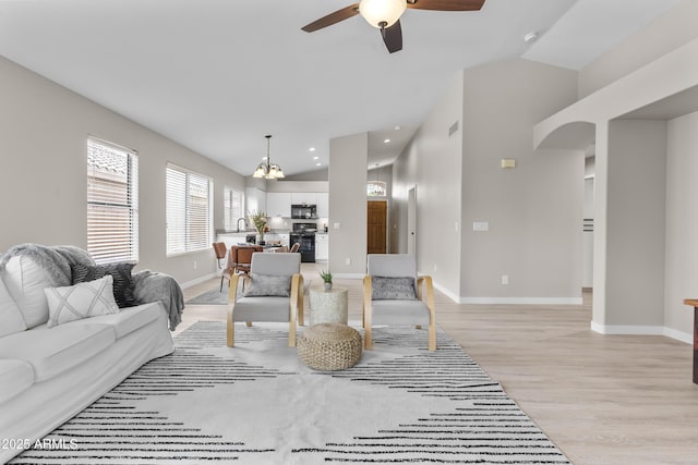 512 W Encinas St, Gilbert, AZ 85233 - living area with vaulted ceiling, a chandelier, baseboards, ceiling fan, and light wood-style flooring