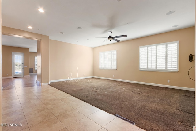 spare room featuring light carpet, ceiling fan, and a healthy amount of sunlight