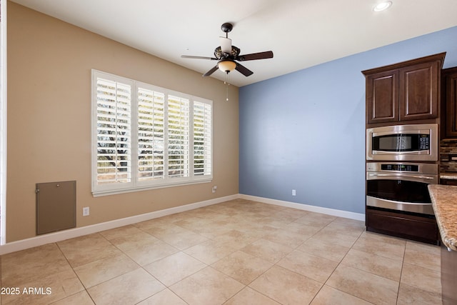 kitchen with stainless steel appliances, ceiling fan, light tile patterned flooring, and dark brown cabinetry