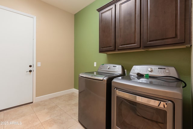 clothes washing area featuring cabinets, independent washer and dryer, and light tile patterned flooring