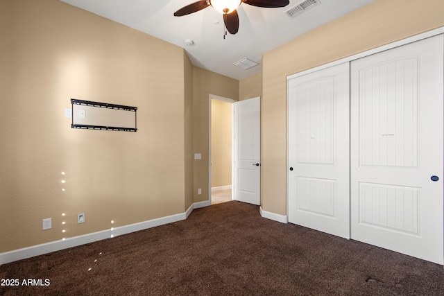 unfurnished bedroom with dark carpet and a closet