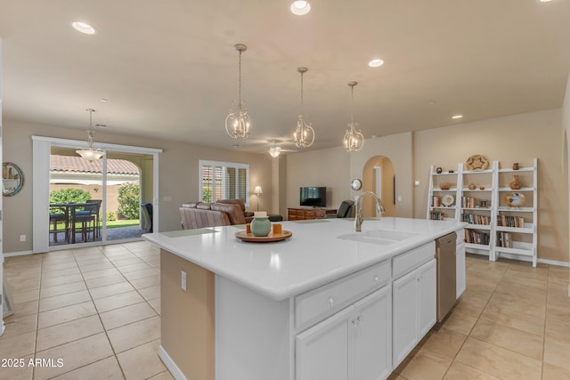 14200 W Village Pkwy Unit 2128, Litchfield Park, AZ 85340 - kitchen with stainless steel dishwasher, light tile patterned floors, arched walkways, light countertops, and an island with sink