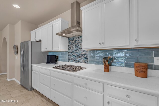 14200 W Village Pkwy Unit 2128, Litchfield Park, AZ 85340 - kitchen with wall chimney exhaust hood, appliances with stainless steel finishes, arched walkways, white cabinets, and light countertops