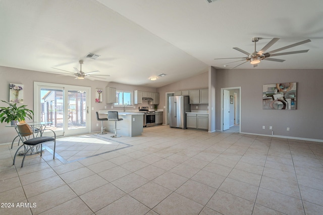 unfurnished living room featuring ceiling fan, light tile patterned floors, and vaulted ceiling