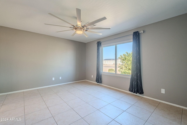 spare room featuring ceiling fan and light tile patterned floors