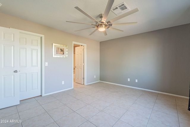 unfurnished bedroom featuring ceiling fan, light tile patterned floors, and a closet