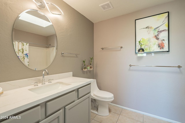 bathroom with toilet, vanity, tile patterned floors, and walk in shower