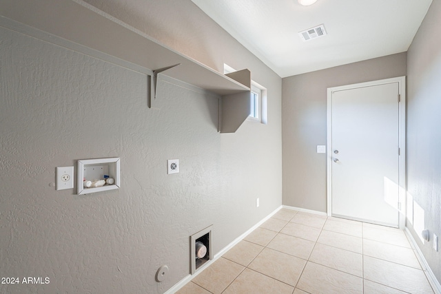 clothes washing area with hookup for a washing machine, hookup for a gas dryer, electric dryer hookup, and light tile patterned flooring