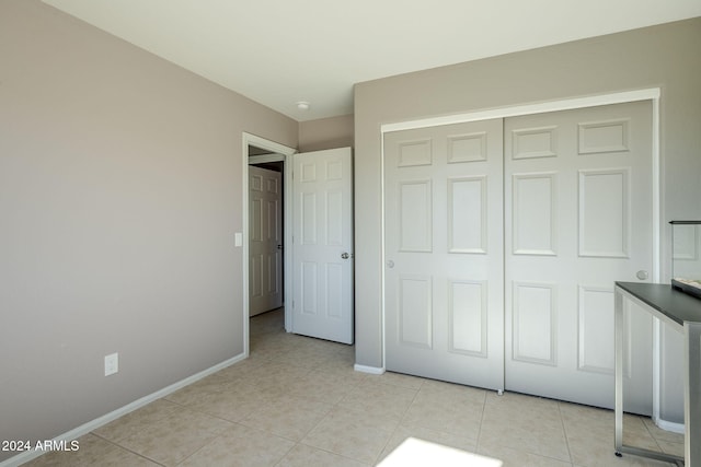 unfurnished bedroom with a closet and light tile patterned flooring