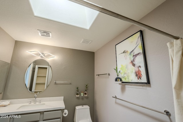 bathroom featuring vanity, toilet, and a skylight