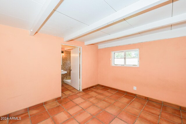 tiled empty room with beam ceiling