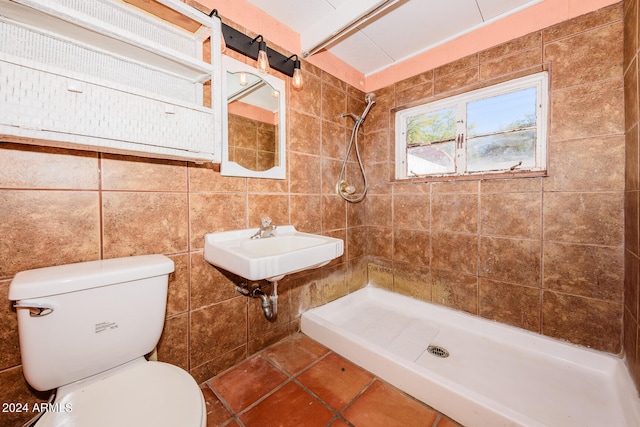 bathroom featuring tile walls, tiled shower, and toilet