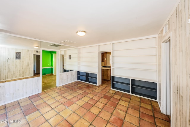 unfurnished room featuring wood walls