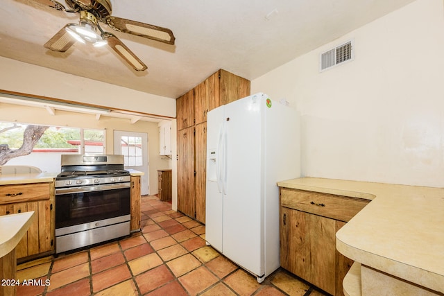 kitchen featuring white fridge with ice dispenser, gas range, and ceiling fan