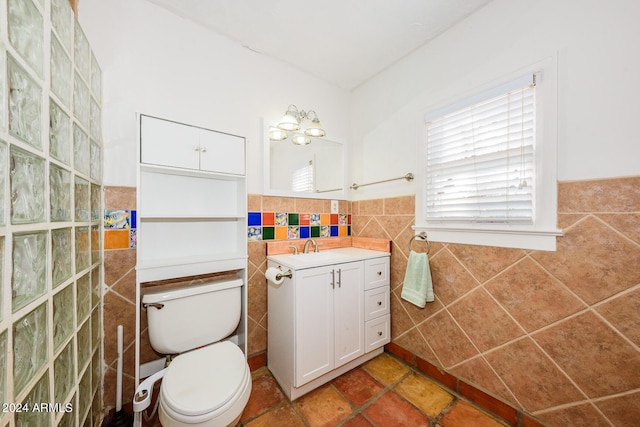 bathroom with tile walls, vanity, and toilet