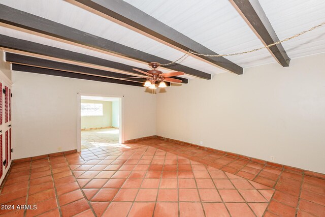 unfurnished room with light tile patterned floors, ceiling fan, and beamed ceiling