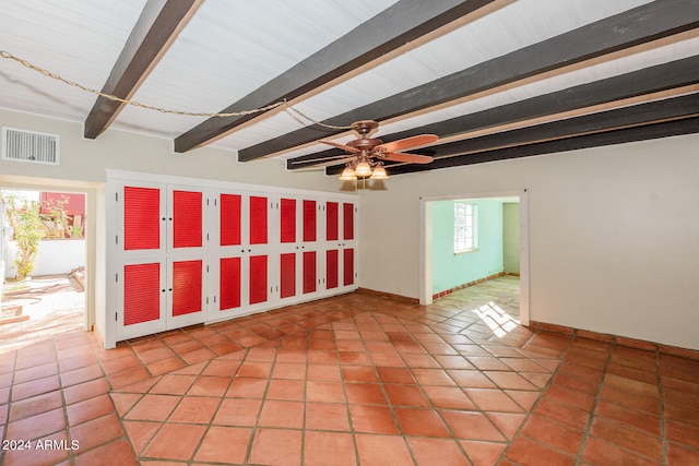 tiled spare room featuring ceiling fan and beamed ceiling