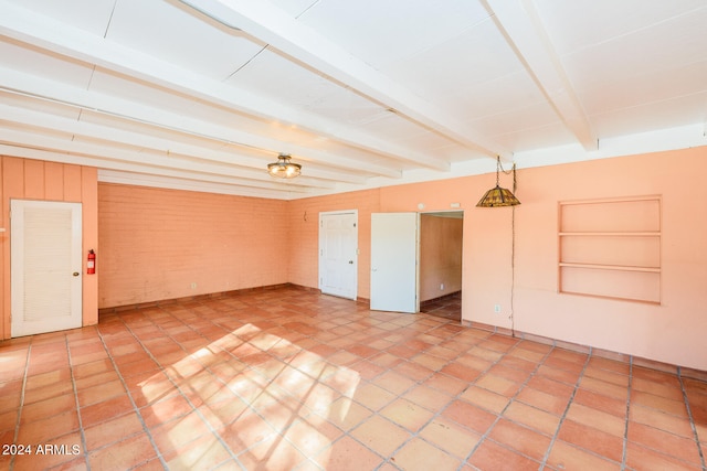 unfurnished room featuring beamed ceiling