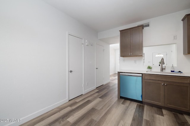 7801 N 44th Dr Unit 1003, Glendale, AZ 85301 - kitchen featuring dishwashing machine, a sink, light wood finished floors, light countertops, and baseboards