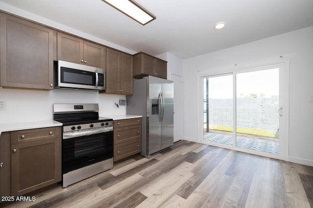 7801 N 44th Dr Unit 1003, Glendale, AZ 85301 - kitchen with stainless steel appliances, light countertops, light wood finished floors, dark brown cabinets, and recessed lighting