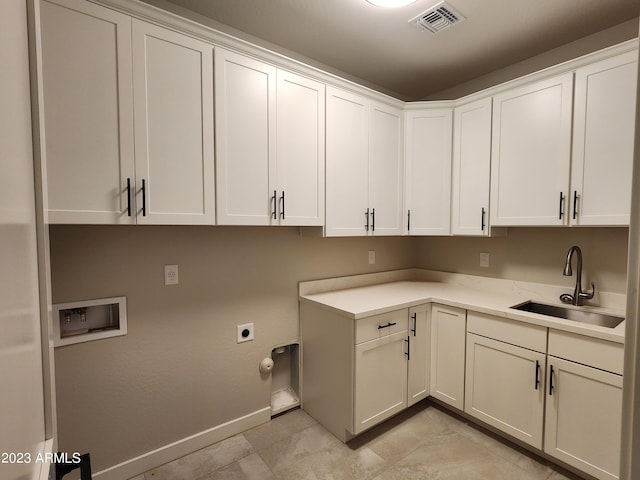 laundry area featuring electric dryer hookup, washer hookup, light tile floors, cabinets, and sink