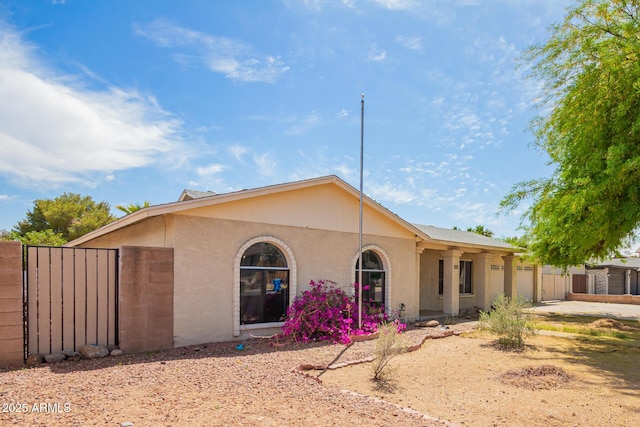 ranch-style house featuring a garage, stucco siding, and driveway