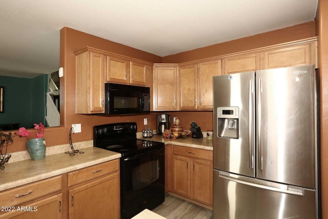 kitchen with black appliances and light hardwood / wood-style flooring