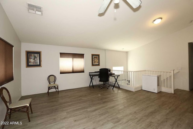 living area featuring hardwood / wood-style flooring, vaulted ceiling, and ceiling fan